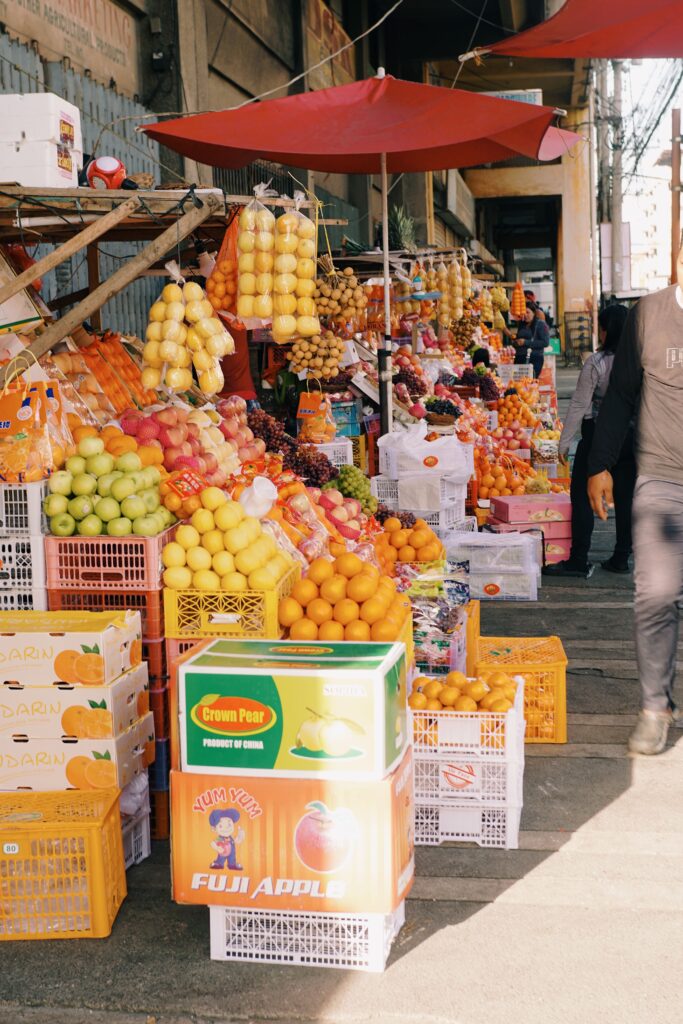 pexels-photo-20274557-20274557 A lively street market with vibrant fruit displays and shoppers exploring the stalls.